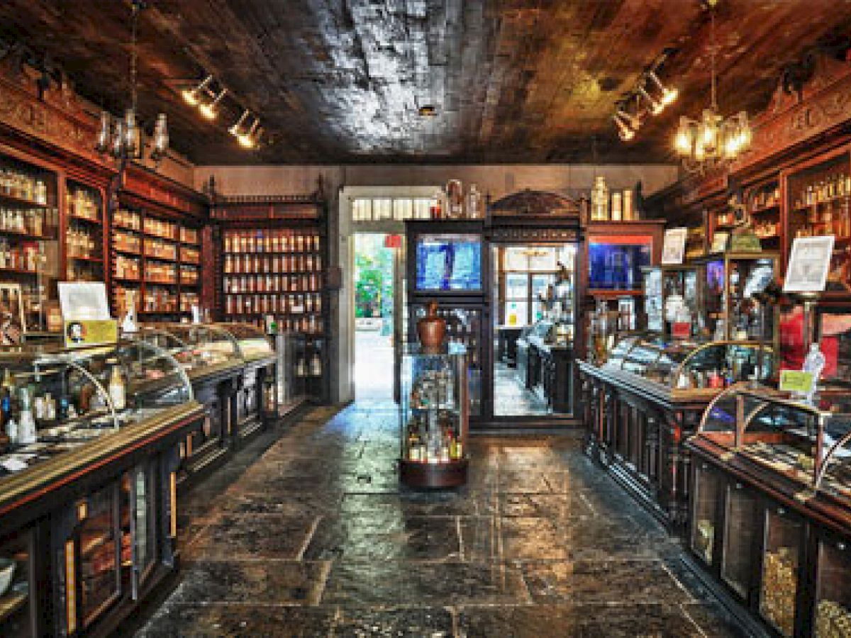 The image shows the interior of an old-fashioned apothecary or pharmacy with wooden shelves, glass display cases, and various bottles and jars.